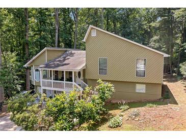 Charming home with a covered porch nestled among lush greenery and mature trees at 592 Ferry Creek Ct, Acworth, GA 30102