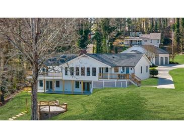 Stunning white home with a finished terrace level and rear decks overlooking the lush backyard at 6313 Shoreland Cir, Buford, GA 30518
