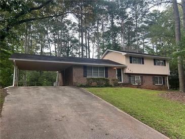 Charming two-story home with a covered parking area and well-maintained front lawn at 4902 Pine Hill E Ct, Stone Mountain, GA 30088