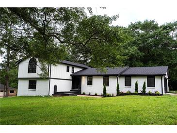 Charming two-story home featuring white brick and siding with a well-manicured lawn at 69 N Hearn Rd, Ellenwood, GA 30294