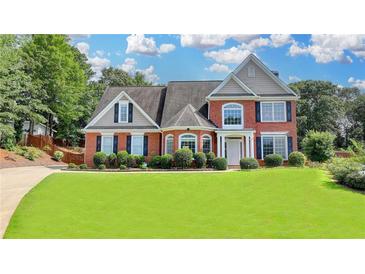 Beautiful brick home features manicured lawn, mature trees, and lovely landscaping at 189 Azalea Chase Dr, Suwanee, GA 30024