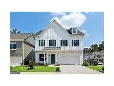 Charming two-story home featuring a bright white facade, black shutters, a well-manicured lawn, and a two-car garage at 247 Widener Way, Peachtree City, GA 30269