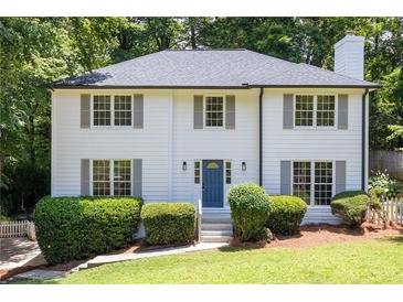 Charming two-story home with a well-manicured lawn, featuring a classic white facade and gray shutters at 1172 Colony Dr, Marietta, GA 30068