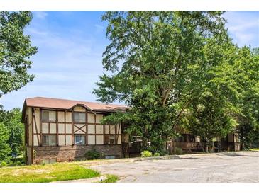 Inviting two-story home showcasing its unique Tudor style and mature trees in a tranquil setting at 1308 Camelot Dr, Atlanta, GA 30349