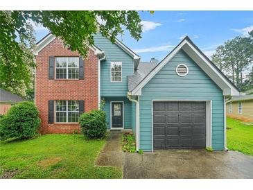 Charming two-story home with a brick facade and blue siding and a well-maintained lawn at 4753 Klondike Cv, Lithonia, GA 30038