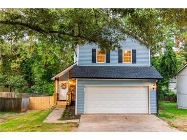 Charming two-story home with blue siding, black shutters, and a well-maintained front yard and a two car garage at 909 Shiloh Ridge Nw Run, Kennesaw, GA 30144