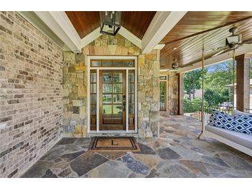 Inviting front porch with stone accents, a porch swing and ceiling fans at 1589 Trentwood Ne Pl, Brookhaven, GA 30319