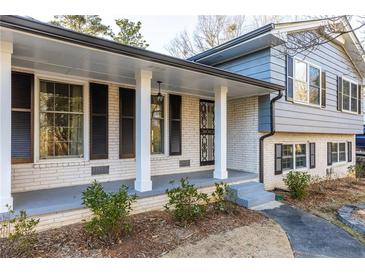 Charming one-story home featuring a brick facade, black shutters, and a covered front porch at 4908 Mill Brook Dr, Atlanta, GA 30338