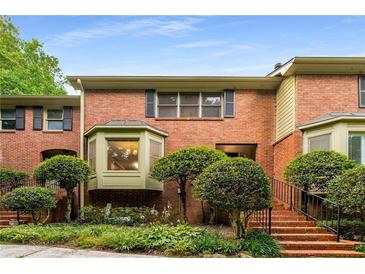 Charming brick townhouse with manicured landscaping and stairs leading to the front door at 1378 Sheffield Glen Ne Way, Atlanta, GA 30329