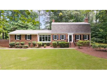 Charming single-story brick home featuring a well-manicured lawn and lush landscaping at 2179 Mountclaire Ct, Stone Mountain, GA 30087