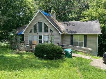 Charming home featuring large windows and covered with green trees at 590 Killian Road Rd, Canton, GA 30114