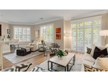 Bright living room features hardwood floors, shutters on the windows and a neutral color palette at 1055 Piedmont Ne Ave # 401, Atlanta, GA 30309