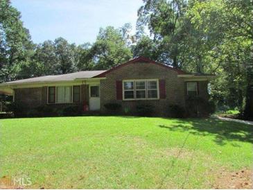 Charming brick home featuring a spacious front yard and mature trees, offering both curb appeal and privacy at 1410 Willis Mill Sw Rd, Atlanta, GA 30311