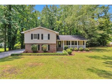 Charming two-story home boasts a welcoming front porch and a well-manicured lawn surrounded by mature trees at 3357 Huntwood Ct, Decatur, GA 30034