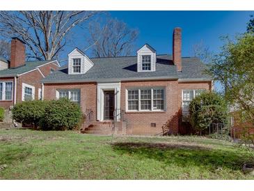 Charming brick home featuring dormer windows, a gray roof, and a well-maintained front yard at 469 Mellview Sw Ave, Atlanta, GA 30310