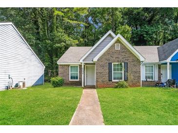 Charming brick home with a manicured lawn and inviting front entrance surrounded by mature trees at 5354 Cherry Wood Drive Dr, Stone Mountain, GA 30083