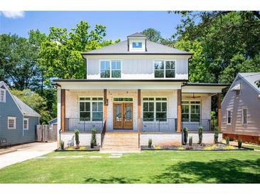 Charming two-story home featuring a brick porch, wood pillars, and well-manicured lawn at 2808 Hosea L Williams Dr, Atlanta, GA 30317