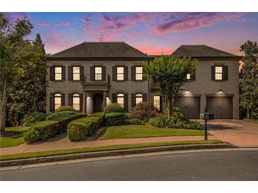 Beautiful home featuring a manicured lawn and a symmetrical facade with a charming balcony and attached two-car garage at 3015 Southmoor Trce, Roswell, GA 30075