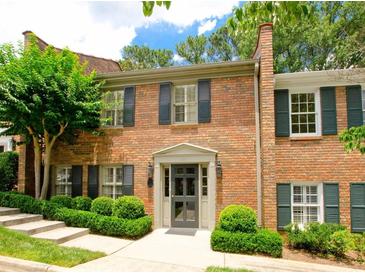 Charming brick townhouse featuring black shutters, manicured landscaping, and a welcoming entrance at 40 Olde Ivy Ne Sq, Atlanta, GA 30342