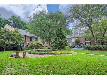 Charming townhomes surround a lush green courtyard with manicured landscaping and mature trees at 1634 Ponce De Leon Ne Ave # 512, Atlanta, GA 30307