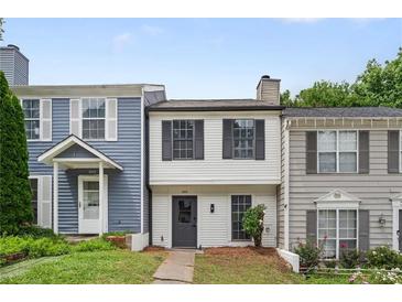 Charming townhome with a well-maintained front yard, neutral exterior, and black shutters on a sunny day at 3072 Revere Ct, Atlanta, GA 30340