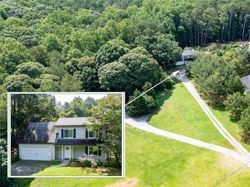Expansive aerial view of a home with a long driveway and surrounding lush greenery and mature trees at 5427 Highway 81, Loganville, GA 30052