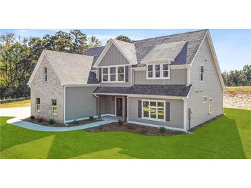 Charming two-story home with light gray siding, brick accent, and a beautifully landscaped front yard at 102 Red Oak Ln, Carrollton, GA 30116