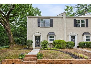 Charming brick townhome featuring a landscaped front yard and classic black shutters at 1767 Defoor Nw Ave # D, Atlanta, GA 30318