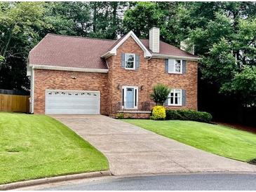 Charming brick two-story home with an attached two-car garage and well-manicured lawn at 4638 Villa Chase Ne Dr, Marietta, GA 30068