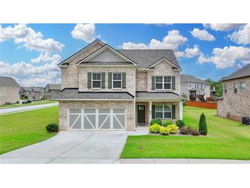Stunning two-story brick home with a two-car garage, well-maintained lawn, and mature landscaping at 2090 Harvester Ln, Buford, GA 30518