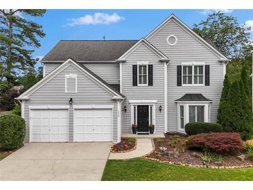 Charming two-story home features a well-manicured lawn, two-car garage, and inviting front entrance at 520 Weatherend Ct, Johns Creek, GA 30022