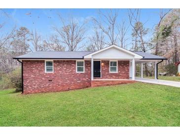 Charming brick home featuring a well-manicured lawn and covered parking area at 101 Longstreet Cir, Oxford, GA 30054