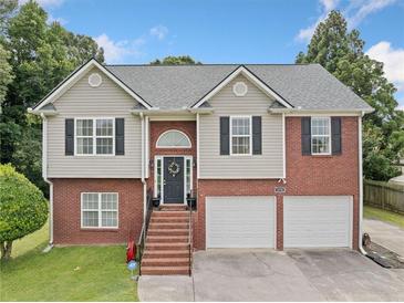 Two-story home featuring a brick and siding exterior, two-car garage, and landscaped front yard at 173 Cline Smith Ne Rd, Cartersville, GA 30121