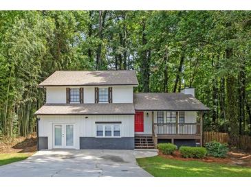 Charming two-story home featuring a welcoming porch and a vibrant red front door at 630 Pennylake Ct, Stone Mountain, GA 30087
