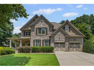 Charming brick home featuring a well-manicured lawn and a convenient two-car garage at 4120 Abingdon, Cumming, GA 30041