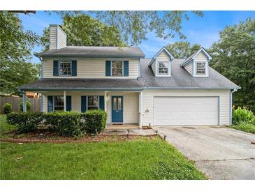 Charming two-story home featuring blue shutters, a well-maintained lawn and two car garage at 4214 Fiddlers Bnd, Loganville, GA 30052