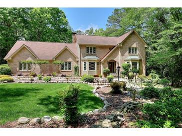 Charming brick home with well-manicured lawn and landscaping, nestled among mature trees at 4853 Carlene Sw Way, Lilburn, GA 30047