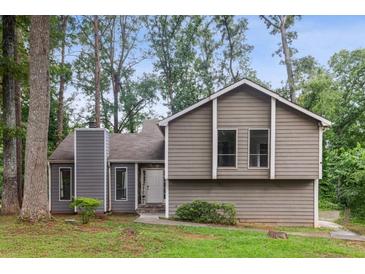 Charming two-story home with neutral siding, manicured lawn, and inviting curb appeal in a lush, wooded setting at 6249 Townsend Way, Riverdale, GA 30296