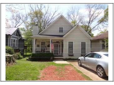 Charming home with a welcoming front porch, American flag, and a silver car parked in the driveway at 1378 Lucile Sw Ave, Atlanta, GA 30310