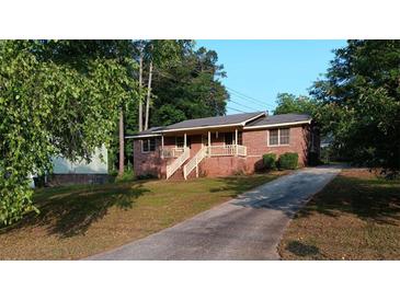 Charming brick home with a covered front porch and long driveway at 9160 Carr Cir, Covington, GA 30014