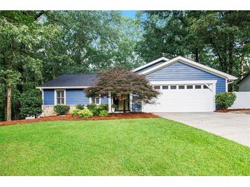 Charming blue home featuring a well-manicured lawn, landscaping, and a two-car garage at 195 Ansley Ct, Roswell, GA 30076