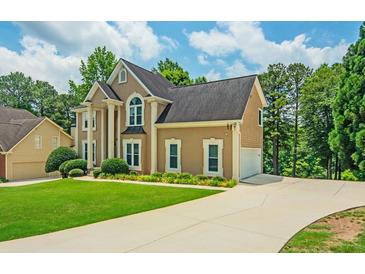Elegant two-story home featuring a spacious driveway and meticulously manicured lawn at 2521 Wood Creek Ct, Dacula, GA 30019