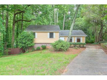 Inviting single-Gathering home featuring a quaint front yard and a long driveway surrounded by mature trees at 3812 Clare Ct, Duluth, GA 30096