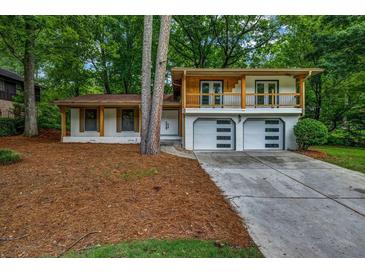 Charming two-story home with white brick, a balcony and a well-manicured lawn at 4260 Bonaparte Dr, Tucker, GA 30084
