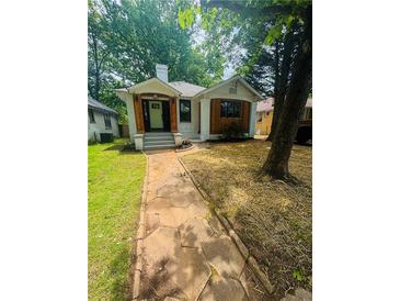 Charming single-Gathering home featuring a stone walkway, lawn, and trees at 1460 Hartford Sw Ave, Atlanta, GA 30310