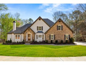 Beautiful two-story home featuring stone and siding exterior, well-manicured lawn, and charming curb appeal at 2410 Glade Overlook, Cumming, GA 30041