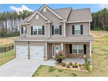 Charming two-story home boasts a welcoming porch, two-car garage, and beautiful curb appeal at 31 Village Trce, Rydal, GA 30171