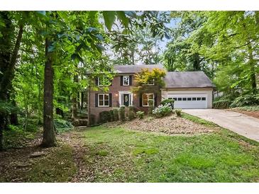 Charming two-story brick home with a well-manicured lawn and mature trees offering curb appeal at 2771 Kenwood Dr, Duluth, GA 30096