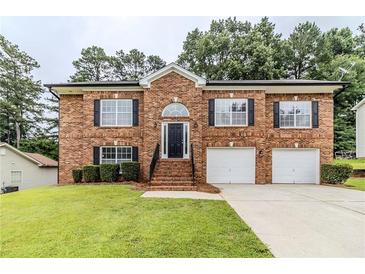 Beautiful two-story brick home with a well-manicured lawn and two-car garage at 6118 Arbor Links Rd, Lithonia, GA 30058