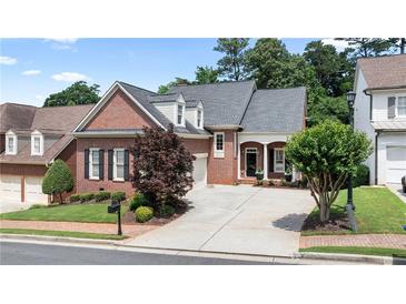 Charming brick home featuring a well-manicured lawn, mature trees, and a private driveway at 1560 Heritage Trl, Roswell, GA 30075
